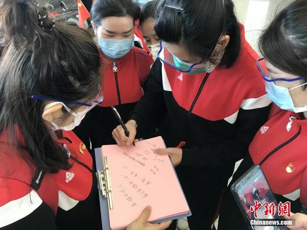 3月17日，海南援助湖北医疗队部分队员将从武汉天河机场乘机离开，医护人员现场留言签名。这批海南援鄂医疗队一共200多人，服务于方舱医院。根据安排，从3月17日起，将组织援鄂医务人员分批撤离湖北。 中新社记者 张芹 摄