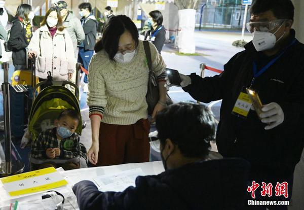东城区工作人员在北京天坛体育场的集散转运中心说着“欢迎回家”，细心、热情接待离鄂返京人员。中新社记者 毛建军 摄