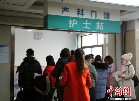 资料图:孕妇在家属的陪同下,在产科门诊前排队测量血压。 赵晓 摄 点击进入下一页
