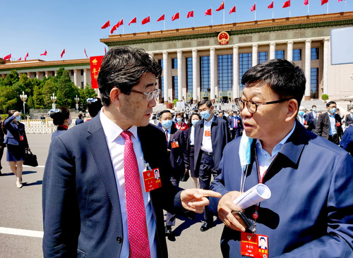 特邀委员记者韩方明（右）在天安门广场就国际疫情合作联防联控情况现场采访医药卫生界委员高福。 特邀委员记者 王众一 摄