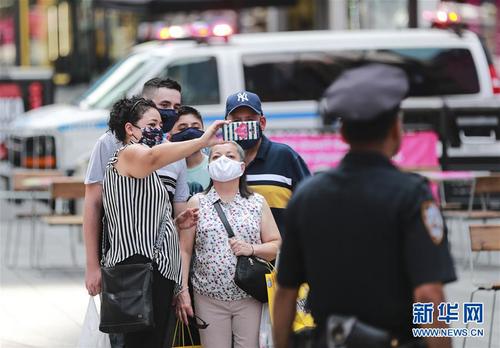 7月23日，人们戴着口罩在美国纽约时报广场拍照留念。 美国约翰斯·霍普金斯大学23日发布的新冠疫情最新统计数据显示，美国累计确诊病例超过400万例。数据显示，截至美国东部时间23日15时34分（北京时间24日3时34分），美国累计确诊病例4007859例，累计死亡病例143846例。 新华社记者 王迎 摄