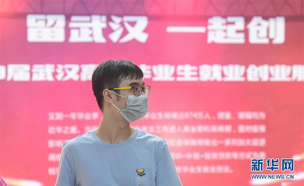 一名求职者在江汉大学校园内举办的招聘会现场寻找合适的岗位（6月1日摄）。这是疫情发生后，武汉举办的首场高校毕业生专场线下招聘会。 新华社记者 程敏 摄