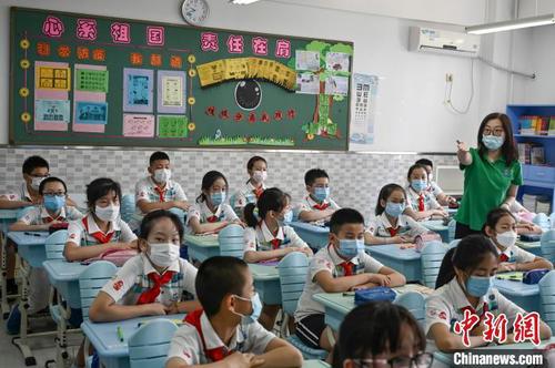 资料图：小学生佩戴口罩返校复课。　张兴龙 摄