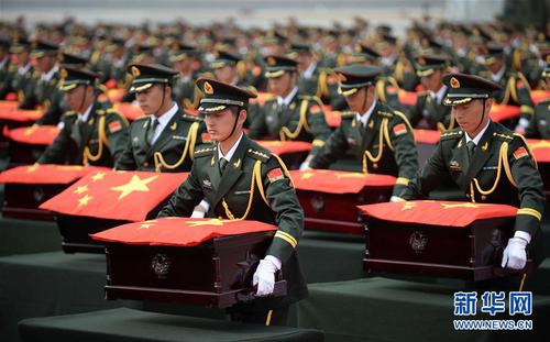 搭载437具中国人民志愿军烈士遗骸的专机降落在沈阳桃仙国际机场，礼兵护送覆盖着国旗的437具志愿军烈士遗骸棺椁进至棺椁摆放区（2014年3月28日摄）。新华社记者潘昱龙摄