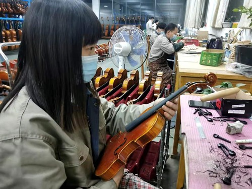 焦继丽在检查小提琴刮板工序。人民政协网记者付振强 摄
