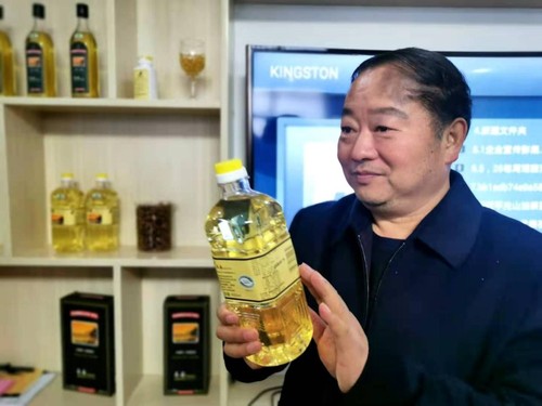 谢焕友向记者介绍食用茶油的好处。人民政协网记者付振强 摄