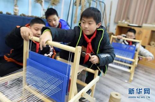 12月22日，浣纱小学五年级学生在用苎麻线织布。