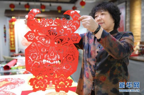 1月29日，在承德市双桥区俊凤剪纸创作室，剪纸艺人石俊凤展示贺岁迎春生肖牛主题剪纸作品。