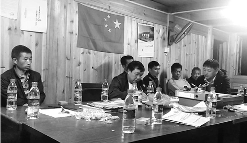 杨星（右一）和村干部开会，研究下一步工作。