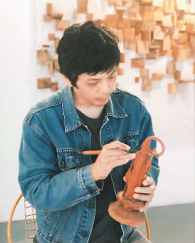 　陈峙峰在雕刻作品。