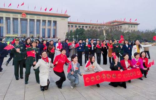 3月7日，三八妇女节即将到来，妇联界别的委员们，会前聚集在广场上挥动着五星红旗合影留念，以纪念这两会期间的妇女节日。特邀委员记者孙太利摄影