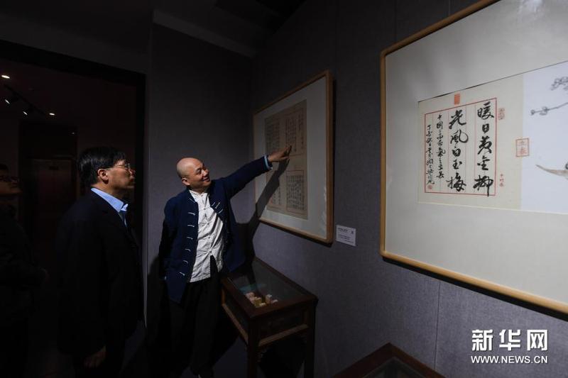 3月16日，在浙江理工大学丝绸博物馆内，国家级非遗项目木版水印技艺代表性传承人魏立中（右）为观众介绍木版水印作品。新华社记者 徐昱 摄