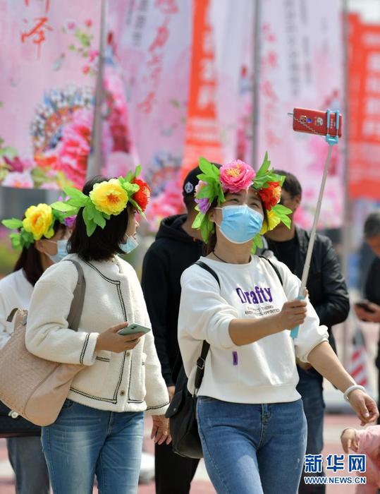 4月8日，头顶“花环”的游客在园内自拍。