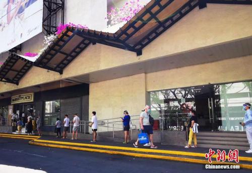 资料图：菲律宾首都马尼拉CBD马卡蒂绿带商圈，市民在超市外排队等候进入采购生活物资。 中新社记者 关向东 摄