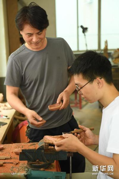 5月24日，徐惠东（左）在位于下涯村的工作室指导徒弟洪明进行茶则制作。新华社记者 翁忻旸 摄