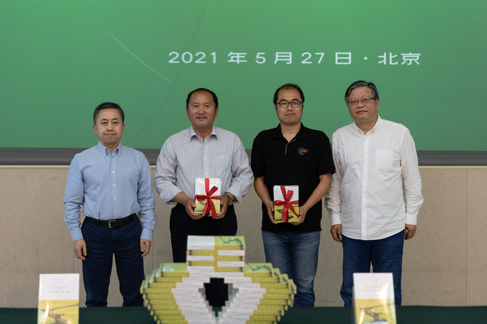 刘文奎（左一）和顾青（右一）分别代表中国扶贫基金会和商务印书馆向中国基金会发展论坛和南峪村赠书。