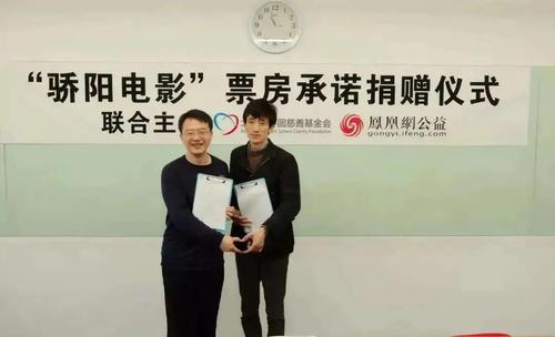 北京同心圆慈善基金会创始人仇序（左）与导演郭家良（右）在“骄阳电影”票房承诺捐赠仪式上