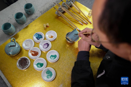 11月21日，在宝丰县一汝瓷工作室，汝瓷艺人在汝瓷茶具上绘画。新华社发（何五昌 摄）