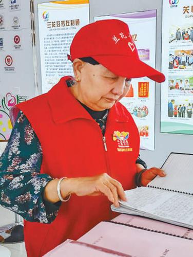 王兰花翻看记录着社区大事小情的“日记” （受访者供图)