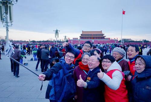 钱海军（前排左三）与志愿者陪伴老人们到天安门广场观看升旗仪式 （受访者供图）
