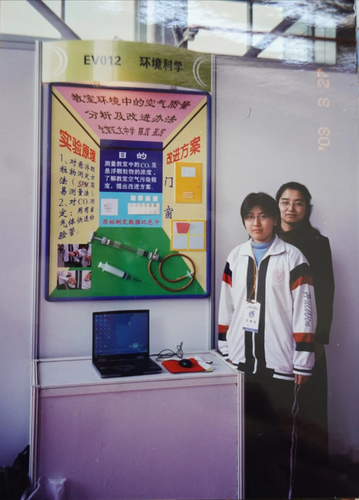 照片三：在2003年北京市青少年科技创新大赛获奖成果展上，与获奖学生合影留念。