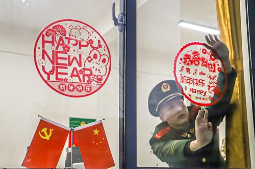 2023年1月17日，河南总队商丘支队组织官兵在营区开展写春联、挂灯笼、贴窗花、晒年货等活动，丰富官兵精神文化生活，营造出喜庆祥和的春节氛围。图为官兵正在张贴窗花。李永超摄