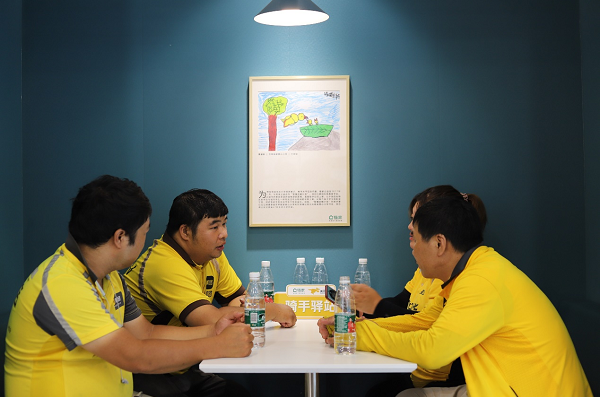 外卖骑手在链家融科橄榄城中心店里休息、聊天