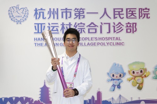 吴珏灿和杭州亚运会火炬“薪火”合影（人民政协报社，受访者供图）