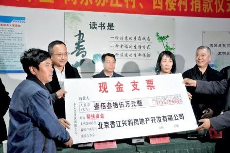 2018 年，吴来盛（左二）与杨莉珊（左四）为天津市武清区河北屯镇的东苏庄村、西 楼村捐款实施自来水管网提升建造工程