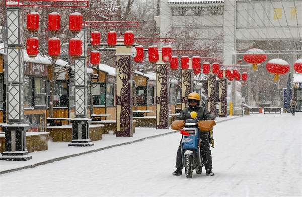 外卖员在乌鲁木齐高新区（新市区）温州街附近配送外卖，将大众所需配送到位。谢龙 摄