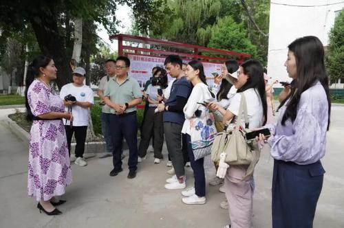 △在新源县喀拉布拉镇，贾娜尔委员（左一）接受记者采访。