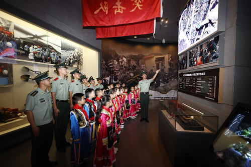 北川中队官兵们为驻地学生讲解部队抗震救灾英雄故事（杨闽摄）
