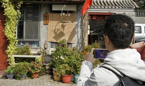 ▲一名游人在钟楼湾胡同内参观拍摄。新华社记者李欣 摄