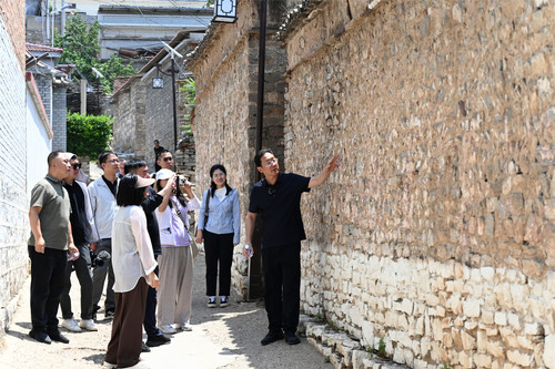 记者跟随董新河委员（右）重走七亘村古道，参观古村落。李若冰 摄