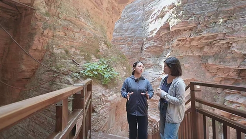 在“瓮圪廊”大峡谷，冯芬芬委员（左）向记者讲述崔振芳烈士的故事。