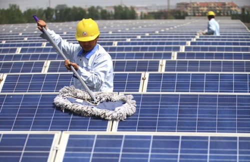 5月12日，技术人员在山东省即墨市大型纺织企业即发集团的厂房屋顶清洁光伏发电面板。