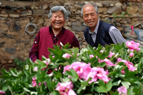 　5月13日，许润枕（右）和老伴儿董振贤在牡丹花前合影。
