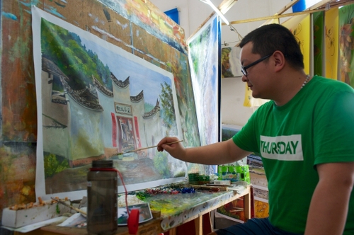 5月15日，上犹油画创意产业园的画师在工作室绘画。