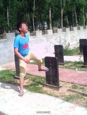 　少年将墓碑踢倒