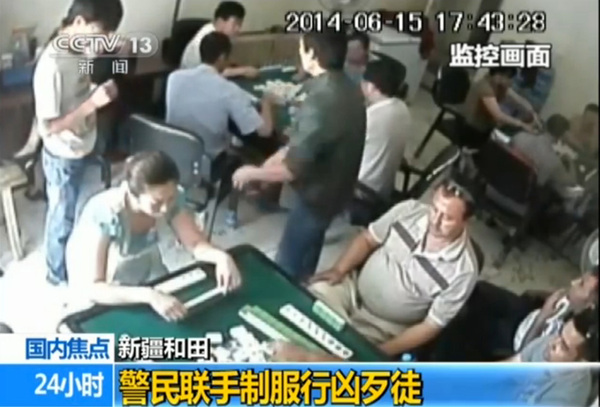 绿衣男子掏出斧头砍向牌客，此时，白衣男子扔若无其事。