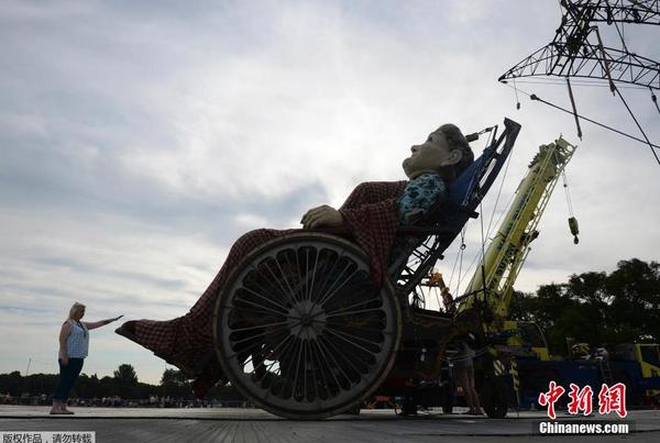 当地时间2014年7月25日，为纪念第一次世界大战爆发100周年，英国利物浦市迎来法国著名木偶剧团皇家豪华的3个巨型木偶，聆听木偶们讲述的一战故事。图为身高7.5米的“老奶奶”。1