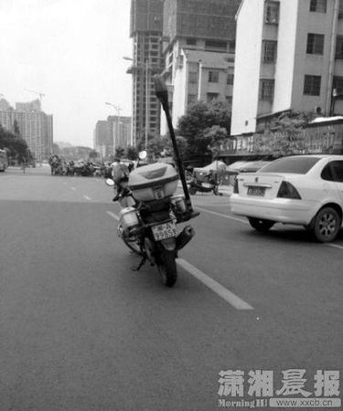 警务摩托车的车牌为“湘A9985警”，停放在主行驶道上。图片来自微博