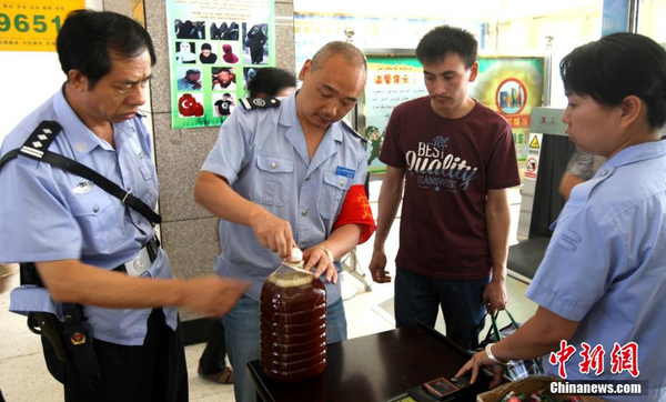 资料图：7月29日，公安民警和安保人员正在克拉玛依客运站进站口严查进站旅客行李和违禁物品。 周建玲 摄