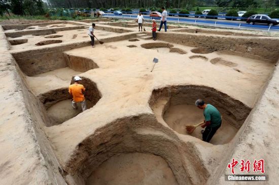 图为考古工作人员发掘工地清理灰坑 图为考古工作人员发掘工地清理灰坑