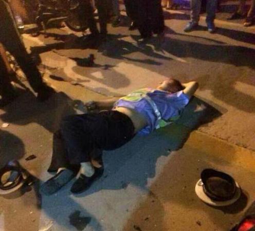几名协警躺在地上一动不动，其中一名协警躺在血泊中。