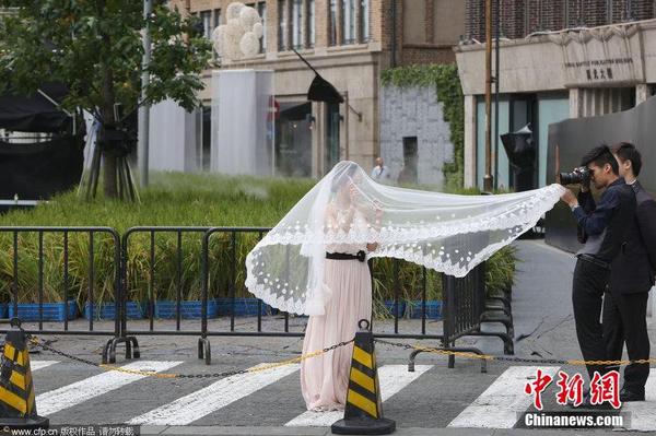图为2014年9月14日，地处上海外滩源的圆明园路“水稻田旁拍婚纱照。1