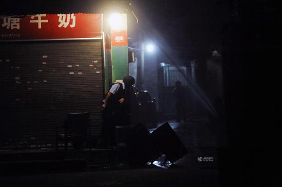 身穿防弹衣的警察在事发现场的巷子口警戒。