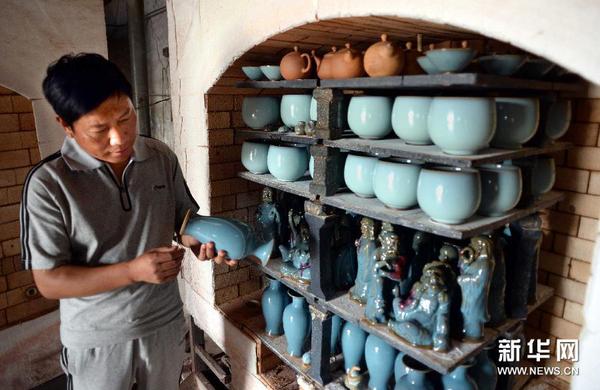 钧瓷工艺大师王建伟在检查刚出窑钧瓷产品的釉色。 钧瓷工艺大师王建伟在检查刚出窑钧瓷产品的釉色。