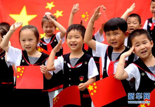 9月28日，安徽淮南市直机关幼儿园的小朋友在国旗前唱《国歌》，庆祝祖国65周岁生日。新华社发（陈彬 摄）