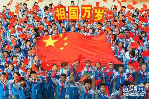 9月26日，安徽省阜阳市北城小学分校的学生与国旗合影。新华社发（王彪 摄）